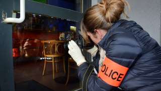 Polizistin nimmt Bilder nach einem Einbruch auf