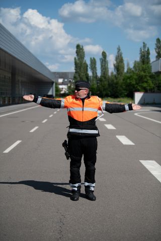 Policier avec bras tendus horizontalement