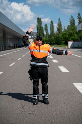 Police officer with left arm extended horizontally and right arm bent at an angle