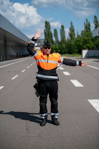 Policier avec bras gauche tendu horizontalement et bras droit plié en équerre