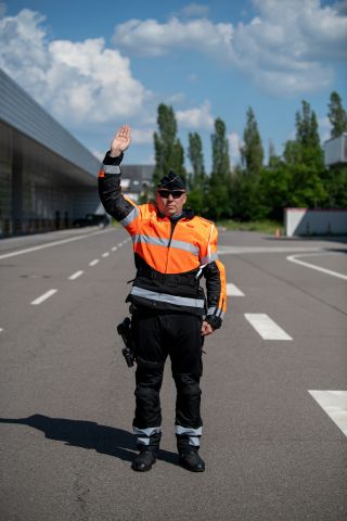 Police officer with arm raised vertically
